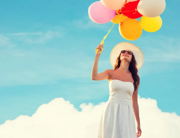 Sorrindo jovem mulher em óculos de sol com balões — Fotografia de Stock