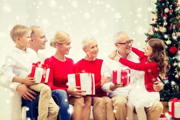 Lächelnde Familie mit Geschenken, die sich zu Hause umarmen — Stockfoto