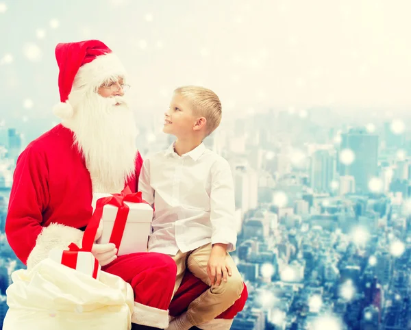 Menino sorrindo com Papai Noel e presentes — Fotografia de Stock