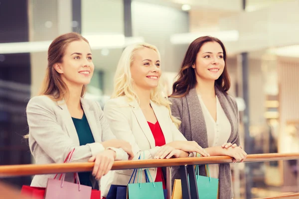 Mulheres jovens felizes com sacos de compras no shopping — Fotografia de Stock