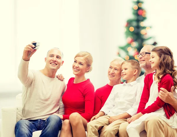 Família sorrindo com câmera em casa — Fotografia de Stock