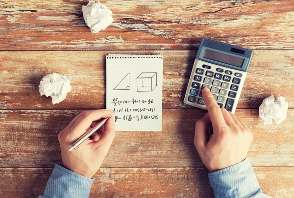 Perto de mãos com tarefa de resolução de calculadora — Fotografia de Stock