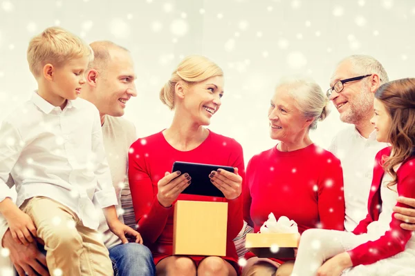 Smiling family with tablet pc and gift box at home — Stock Photo, Image