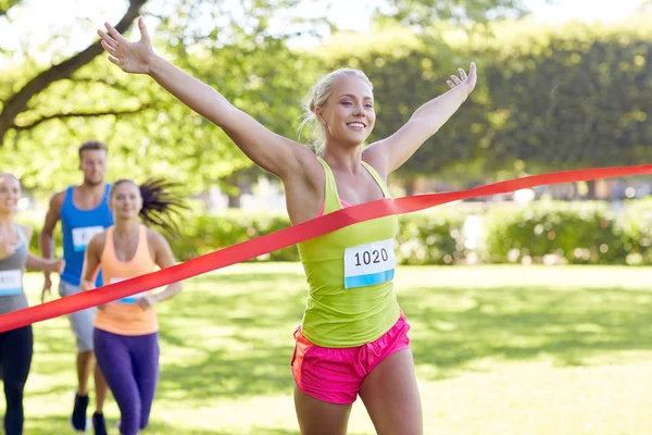 Feliz jovem corredor feminino ganhando no acabamento da corrida — Fotografia de Stock