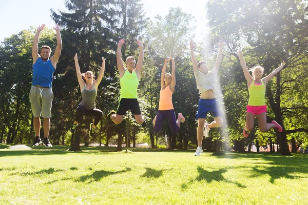 Groep gelukkige vrienden hoog springen buitenshuis — Stockfoto
