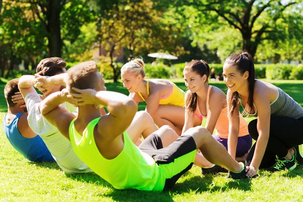 Group of friends or sportsmen exercising outdoors — Stock Photo, Image