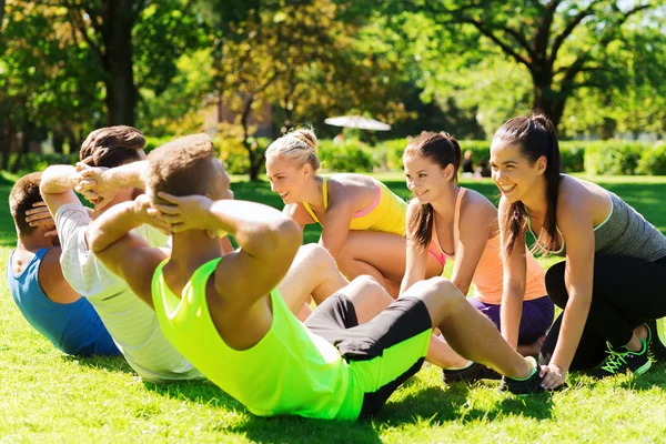 Grupo de amigos o deportistas que hacen ejercicio al aire libre — Foto de Stock