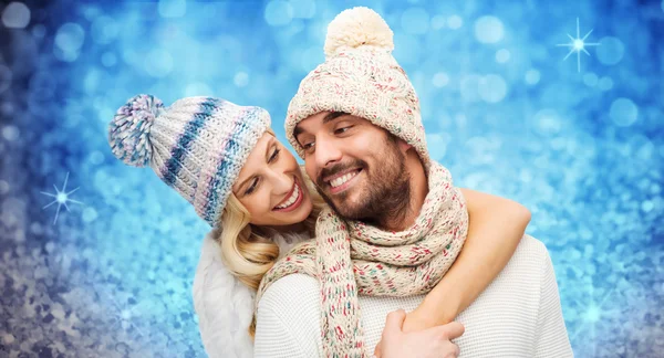 Happy couple in winter clothes hugging over lights — Stockfoto