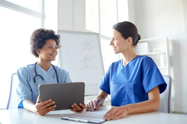 Medici felici con tablet pc riunione in ospedale — Foto Stock