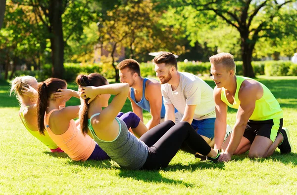 Grupo de amigos o deportistas que hacen ejercicio al aire libre — Foto de Stock