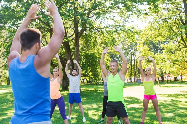 Grupo de amigos o deportistas que hacen ejercicio al aire libre — Foto de Stock