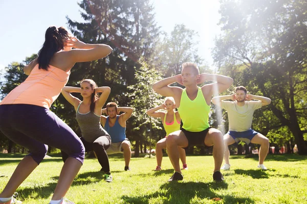 Grupo de amigos o deportistas que hacen ejercicio al aire libre Imagen de stock