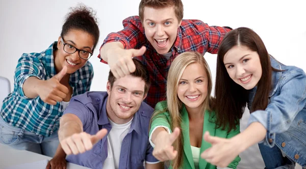 Grupo de estudiantes felices mostrando pulgares hacia arriba Imagen De Stock