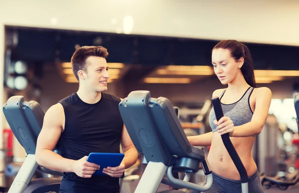 Vrouw met trainer uitoefenen op stepper in gym — Stockfoto