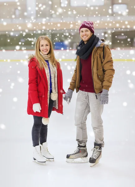 Feliz pareja cogida de la mano en pista de patinaje —  Fotos de Stock