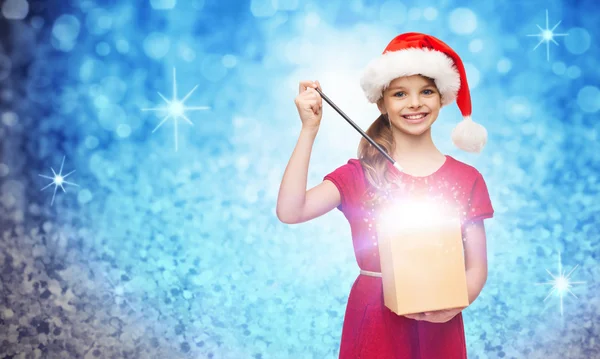 Chica sonriente en sombrero de ayudante de santa con caja de regalo — Foto de Stock