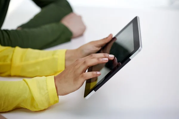 Primer plano de las manos femeninas con tableta pc en la mesa — Foto de Stock