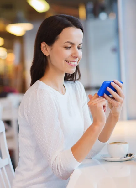 Smartphone ve kafede kahve ile gülümseyen kadın — Stok fotoğraf