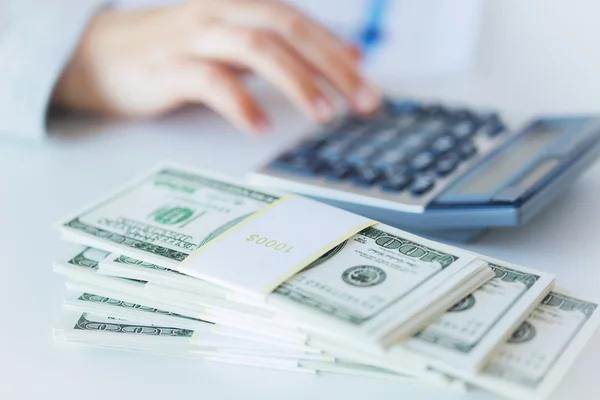 Close up of hand counting money with calculator — Stock Photo, Image