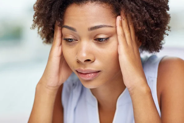 Close up of african young woman touching her head — Stock Photo, Image