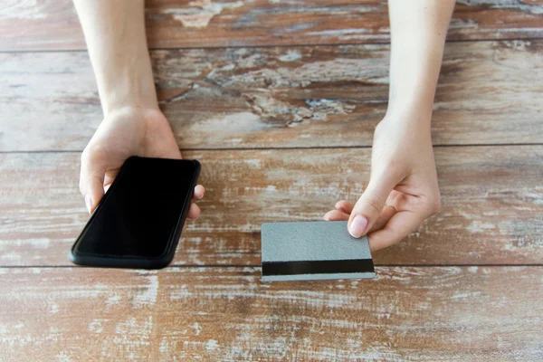 Primo piano delle mani con smart phone e carta di credito — Foto Stock