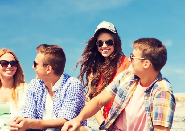 Grupo de amigos sonriendo sentados en la calle de la ciudad — Foto de Stock