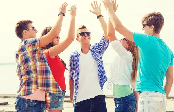 Group of smiling friends making high five outdoors — Stock Photo, Image