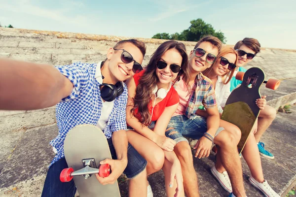 Groep lachende vrienden met smartphone outdoors — Stockfoto