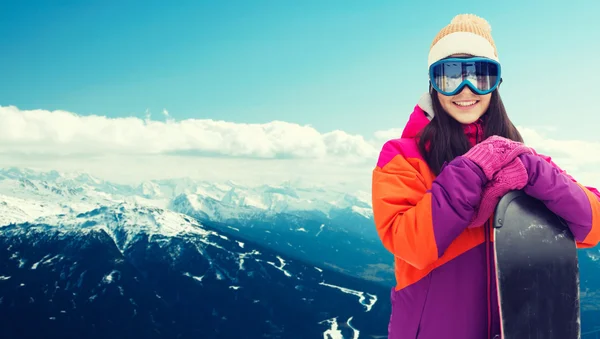 Happy young woman with snowboard over mountains — Stock Photo, Image