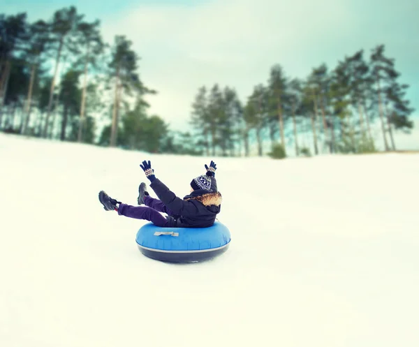 Jovem feliz deslizando para baixo no tubo de neve — Fotografia de Stock