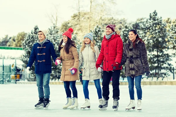 Happy vänner skridskoåkning på isbanan utomhus — Stockfoto