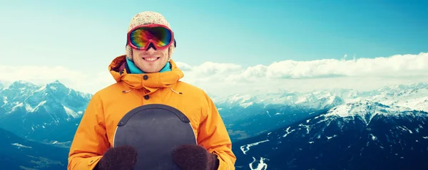 Happy young man in ski goggles over mountains — Stock Photo, Image