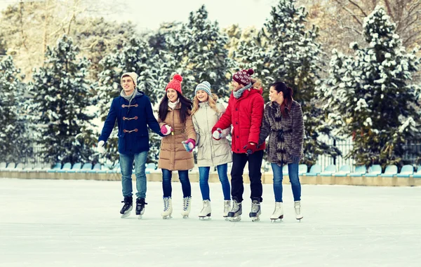 Happy vänner skridskoåkning på isbanan utomhus — Stockfoto