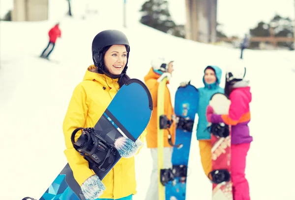 Amigos felizes em capacetes com snowboards — Fotografia de Stock