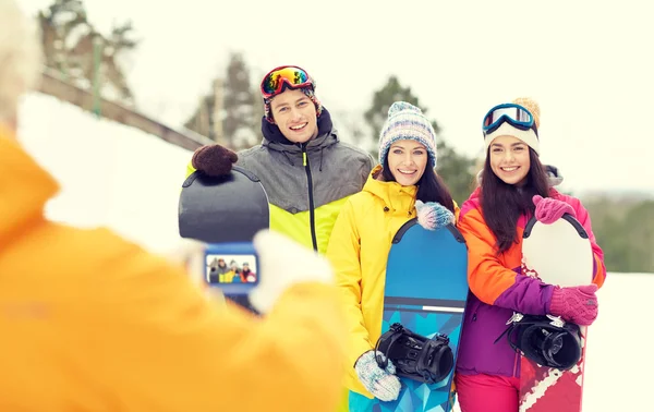 Amis heureux avec snowboards et smartphone — Photo