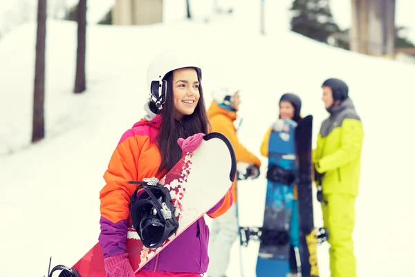 Amigos felices en cascos con snowboards —  Fotos de Stock