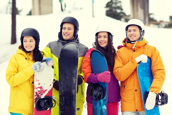 Glückliche Freunde in Helmen mit Snowboards — Stockfoto