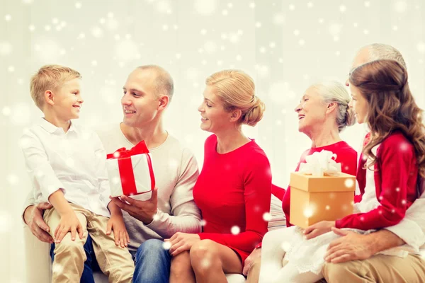 Smiling family with gifts talking at home — Stock Photo, Image