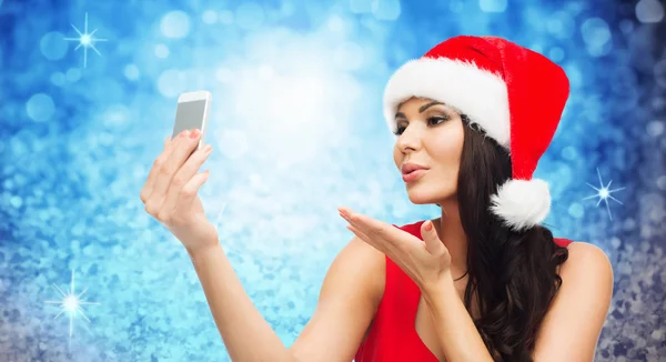 Woman in santa hat taking selfie by smartphone — Stock Photo, Image