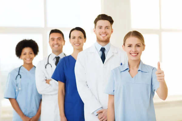 Happy doctors showing thumbs up at hospital — Stock Photo, Image