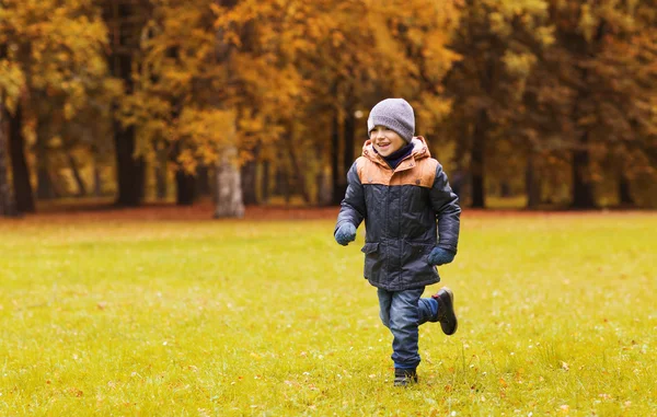 Menino feliz correndo no campo do parque de outono — Fotografia de Stock