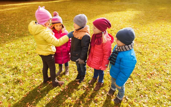 Kids in autumn park counting and choosing leader — Stockfoto