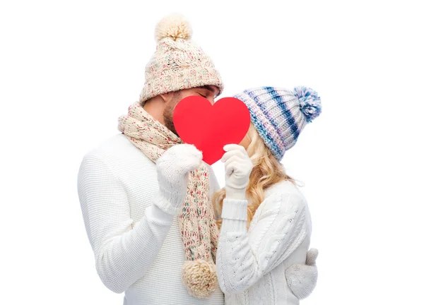Улыбающаяся пара в зимней одежде с красным сердцем — стоковое фото