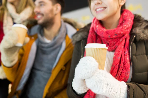 Amis heureux avec tasses à café sur patinoire — Photo