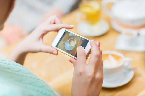 Закрыть глаза на смартфон женщины, изображающий чашку кофе — стоковое фото
