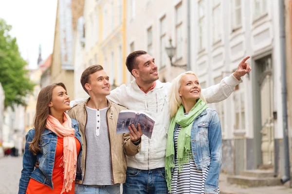 Group of friends with city guide exploring town — Stock Photo, Image