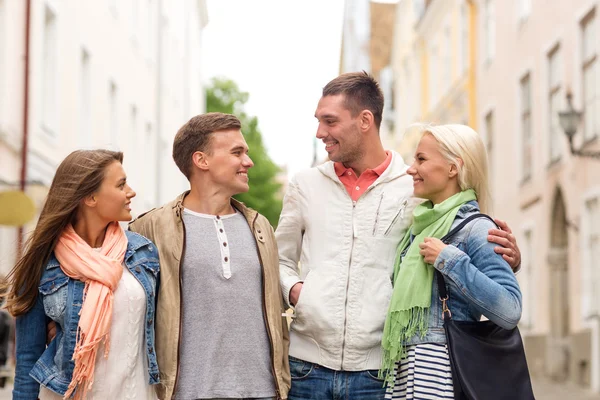 Groep lachende vrienden wandelen in de stad — Stockfoto