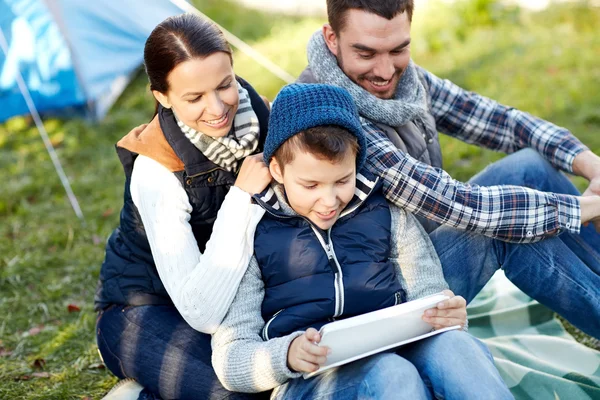 Familia feliz con tableta PC y tienda de campaña en el camping —  Fotos de Stock