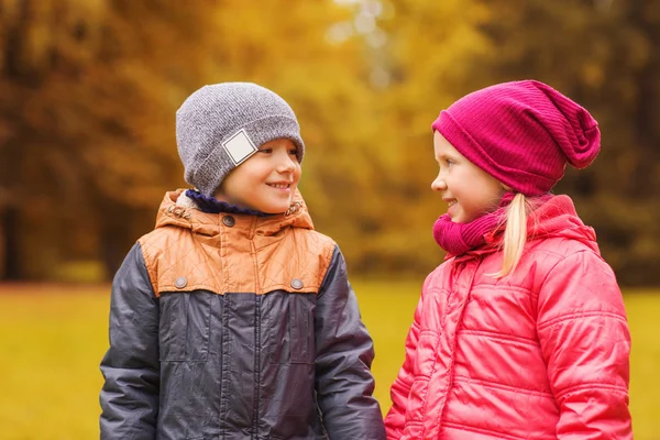 Feliz niña y niño hablando en el parque de otoño —  Fotos de Stock