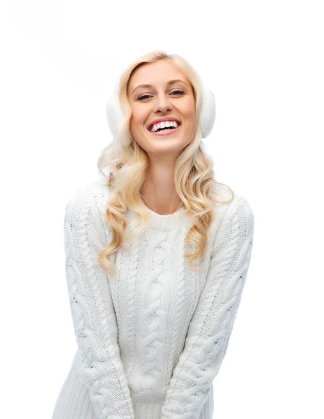 Улыбающаяся молодая женщина в зимних наушниках и свитере — стоковое фото